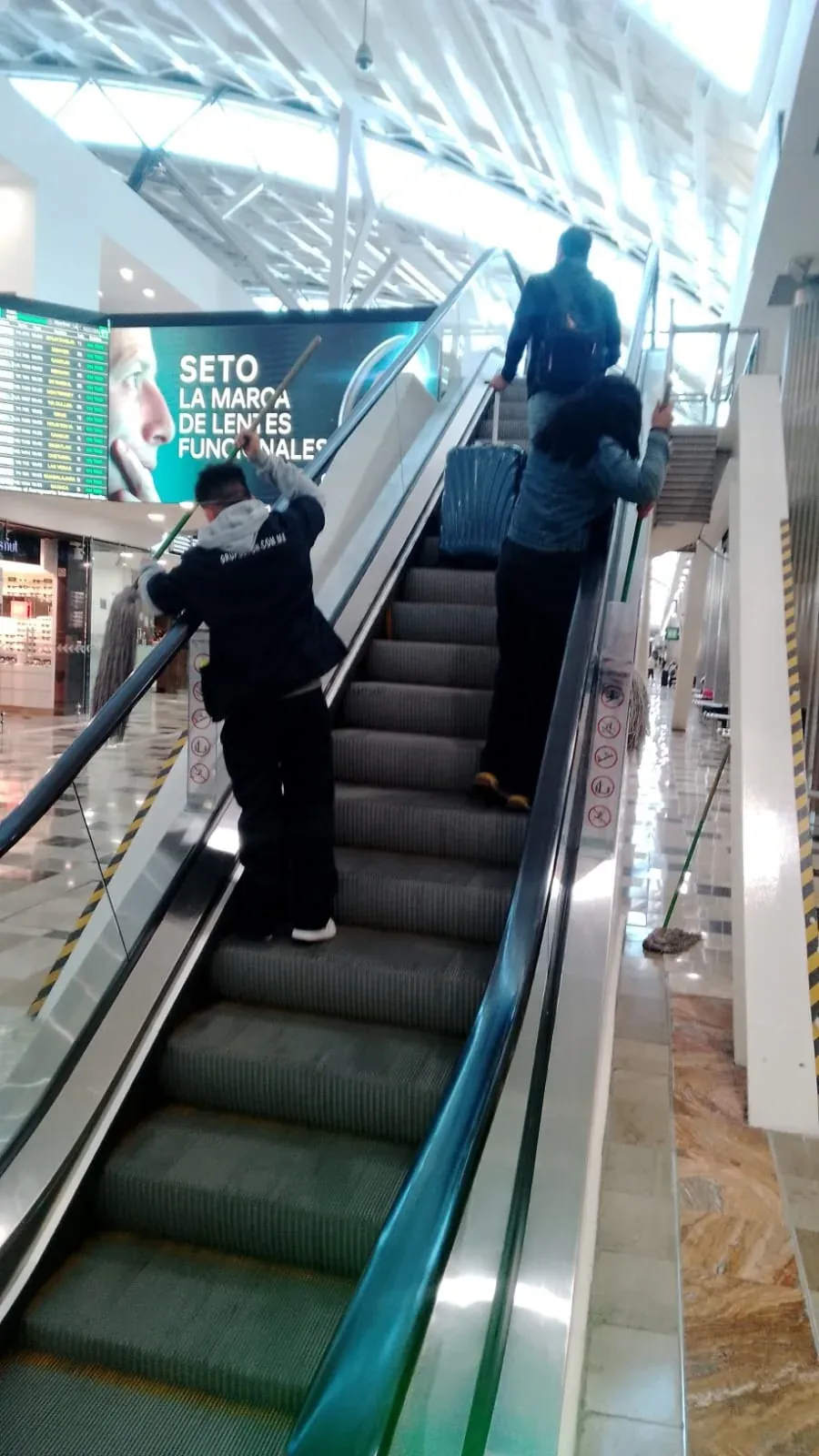 Personal de Grupo Lyon limpiando las escaleras eléctricas de la Puerta 3 del aeropuerto