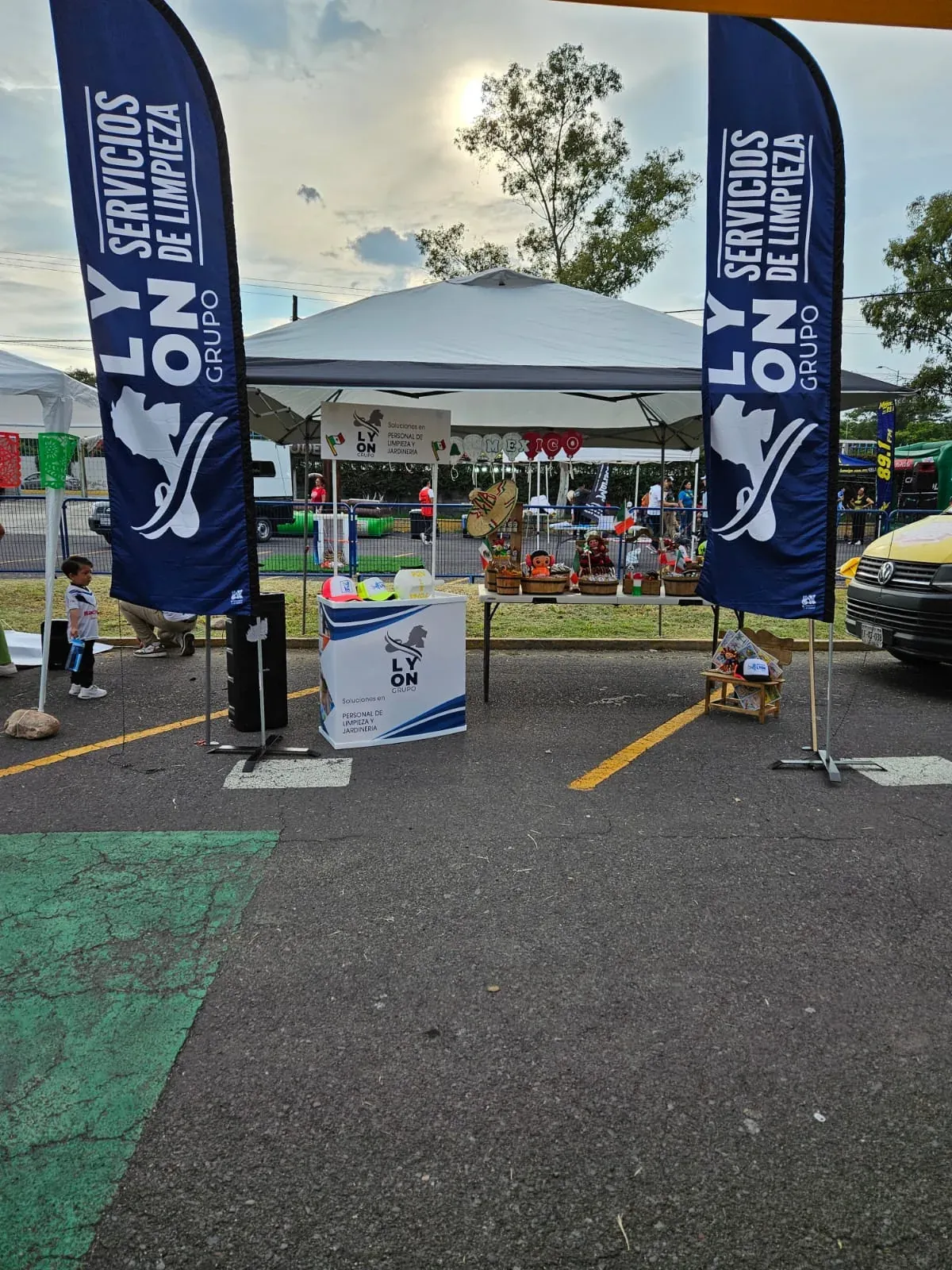 Stand de Grupo Lyon con banderas de Servicios de Limpieza en un evento al aire libre